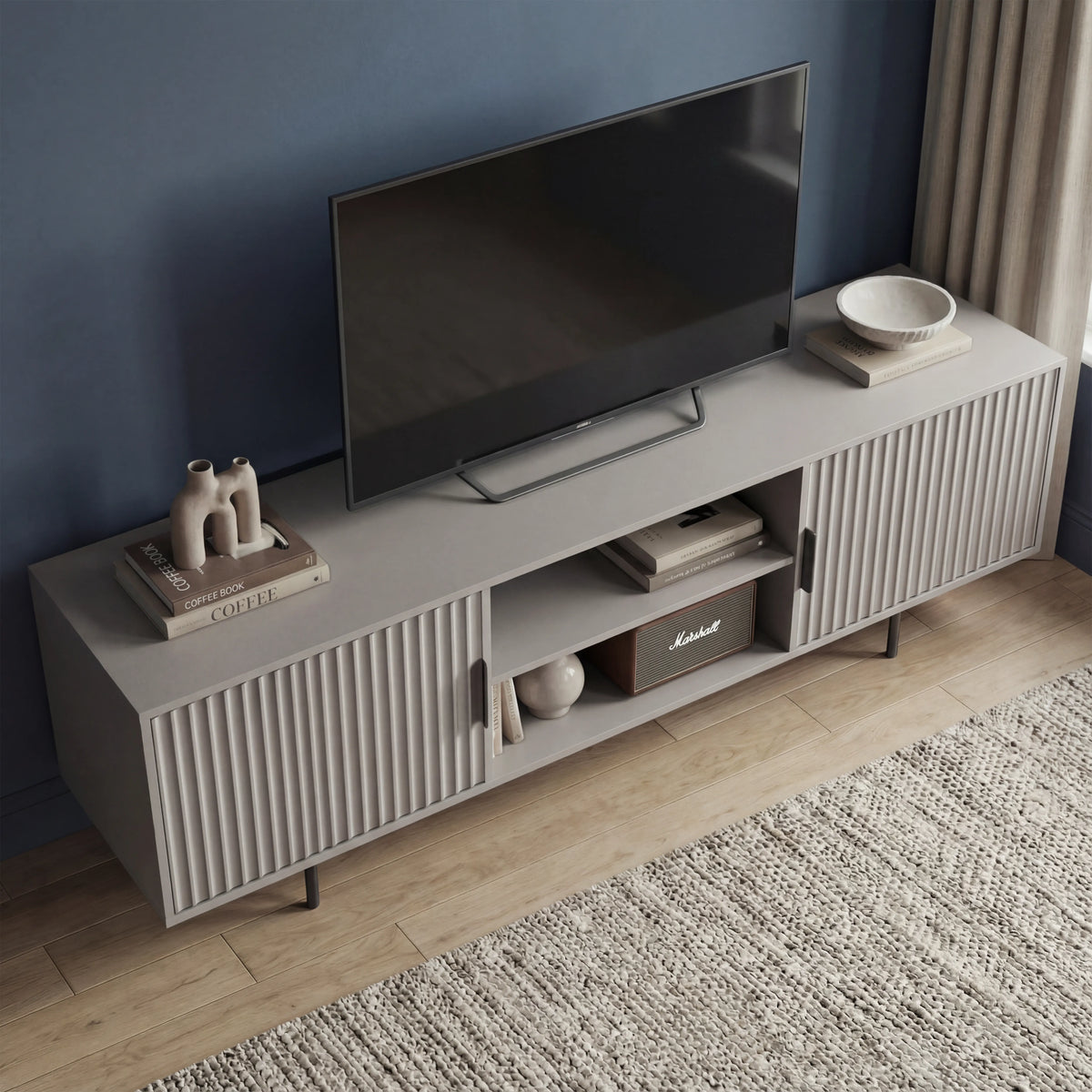 [Grey] Wide grey 180cm TV unit lifestyle with TV mounted on navy wall, ceramic figures left and decorative bowl right.