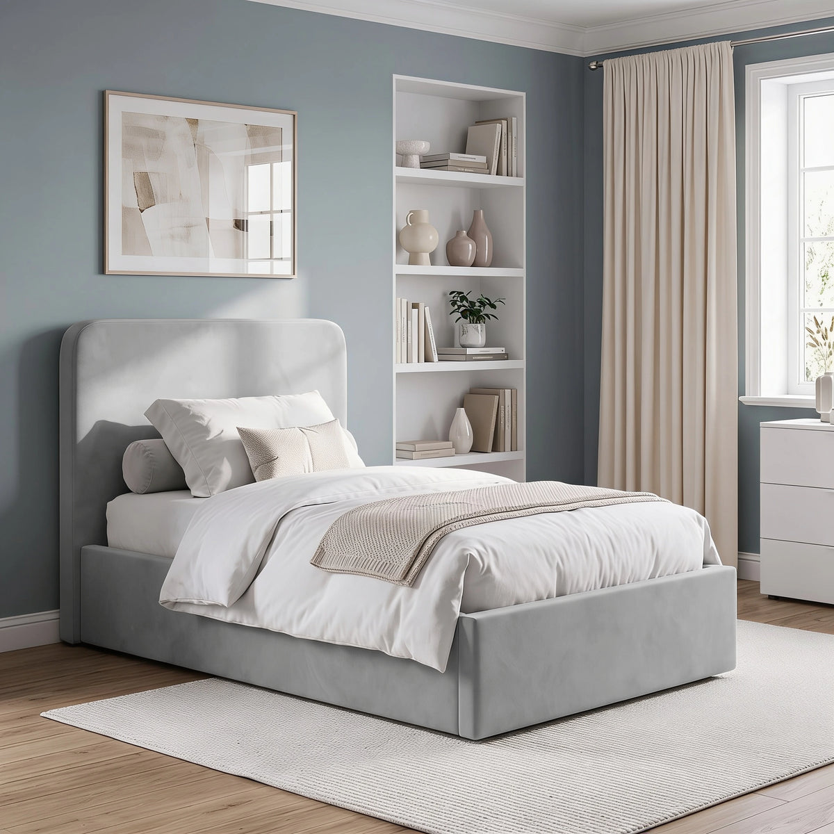 [Light Grey | Small Double] velvet upholstered bed frame with a tall headboard, shown in a styled bedroom setting with white bedding, a beige throw blanket, a nightstand, and a blue-gray wall.