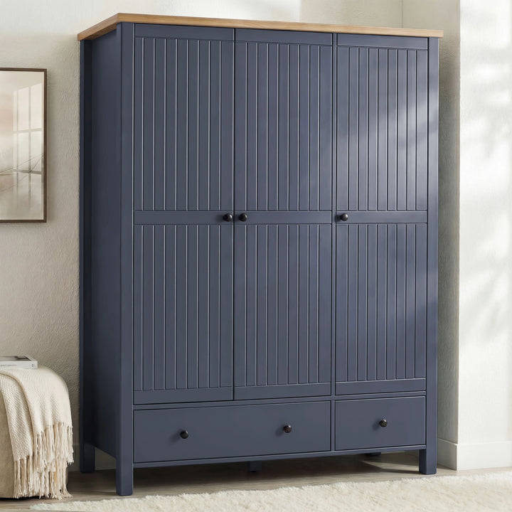 [Blue] Linra wardrobe in blue with three closed grooved doors, oak top, two base drawers, and brass knobs