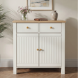 [White] Linra sideboard front view with oak top surface styled with a book, botanical print, and pampas grass vase in natural light