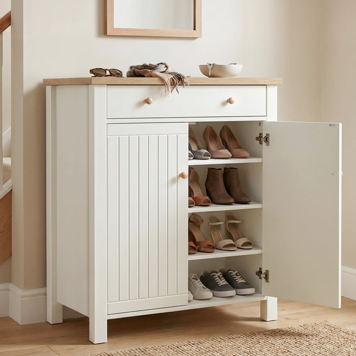[White] Linra White 4 Tier Painted Shoe Storage Cabinet with one slatted door opened to reveal women's high heels, ankle boots, and casual sneakers organized cleanly on its shelves.