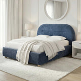 [Blue | Double] Angled view of upholstered bed frame revealing headboard depth beside floating nightstand and ceramic lamp