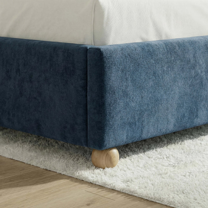 [Blue | King] Close-up of spherical natural wood leg supporting the velvet padded bed base on pale floor