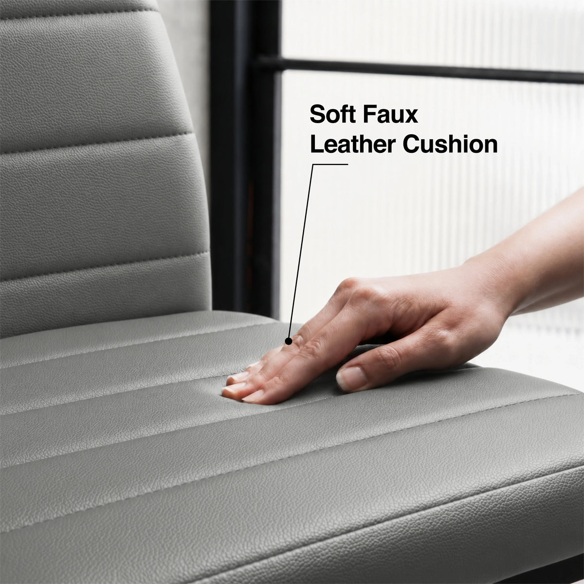 [6 Seater | Grey] Close-up of the Milo faux leather chair cushion with stitched padding pressed by a hand