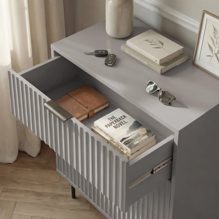 [Grey] bedside cabinet unit with a flutrina front and an open drawer containing neatly organised items