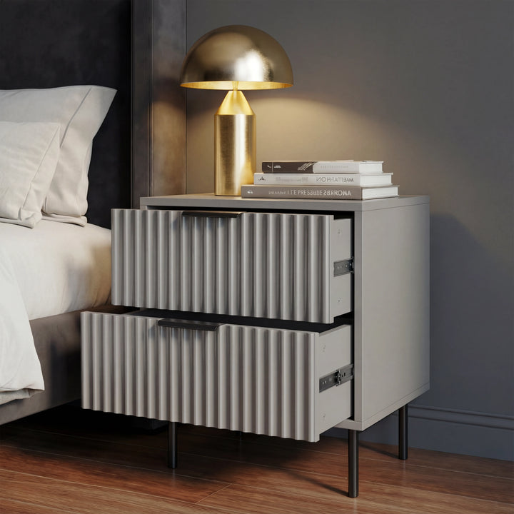 [Grey] flutrina design bedside table with two partially opened drawers, and black legs positioned beside a bed
