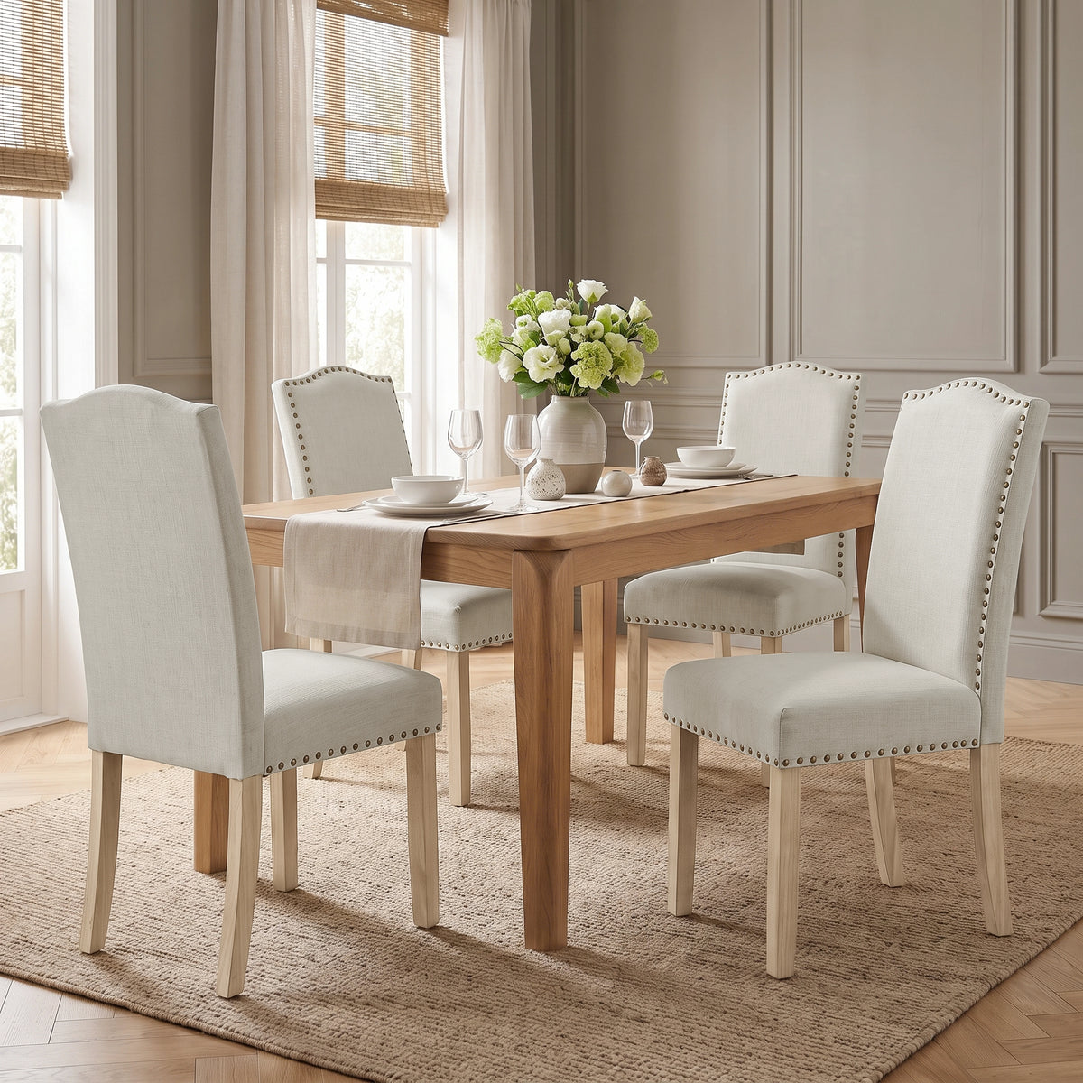[Beige | Set of 4] Nailhead Dining Chairs set of 4 in beige fabric styled around a wooden dining table.