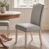 [Light Grey | Set of 2] Nailhead dining chair beside a round wooden table in a bright dining room