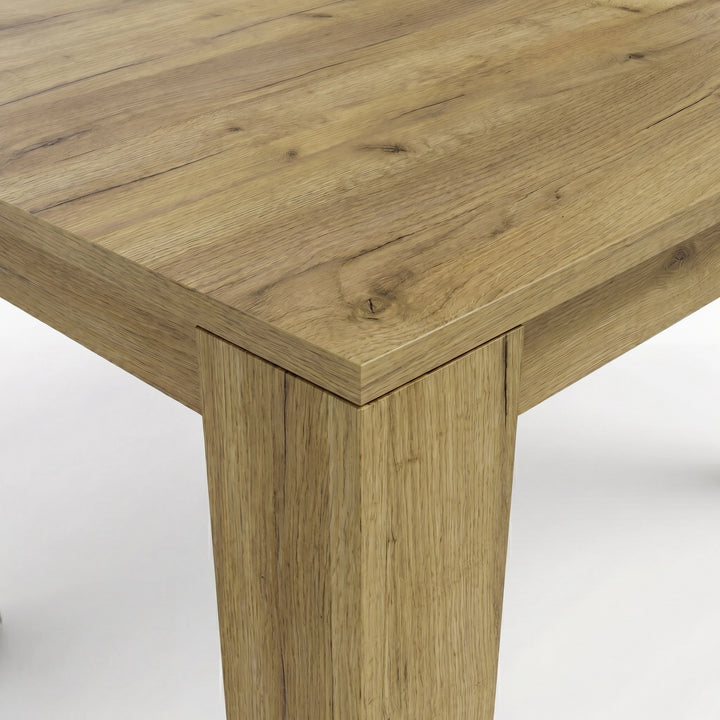 [Oak] Close-up of the oak-effect tabletop corner and thick L-shaped leg; natural-looking grain covers both surfaces.