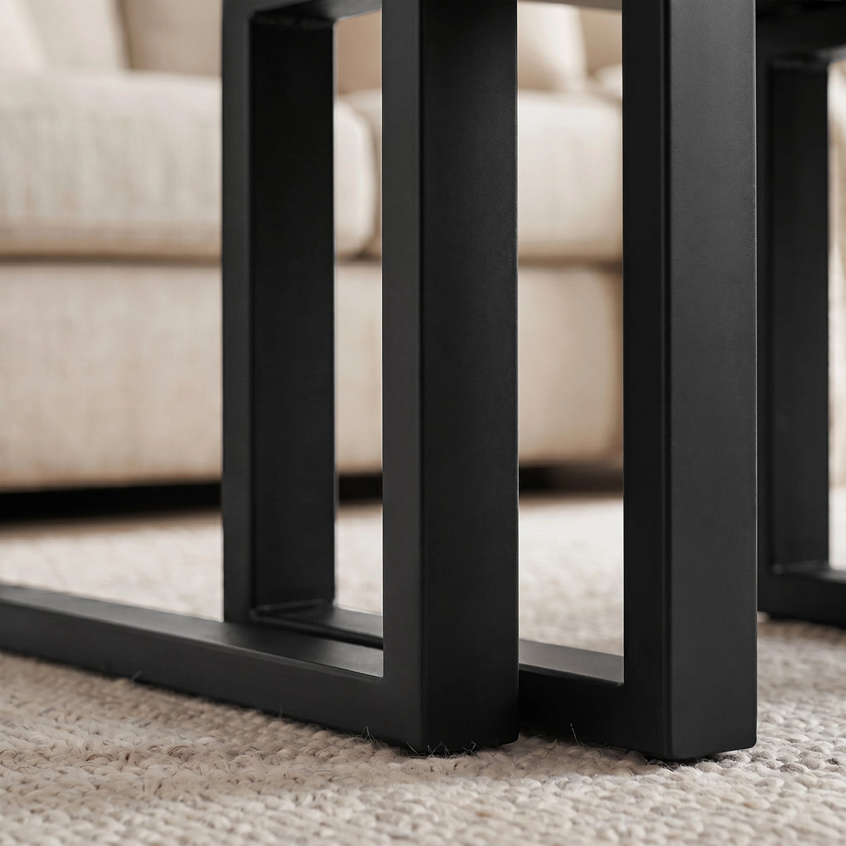 [Concrete] Nestline nesting coffee table detail with nested frame detail with black metal legs aligned beneath the grey