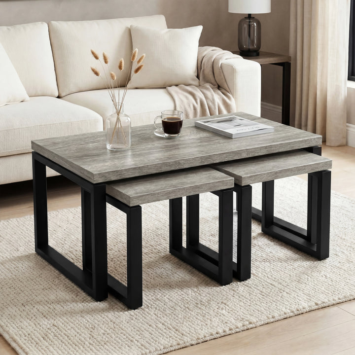 [Grey] Nestline coffee table set beside a cream sofa, with soft cushions, flowers, and nesting side tables pulled out