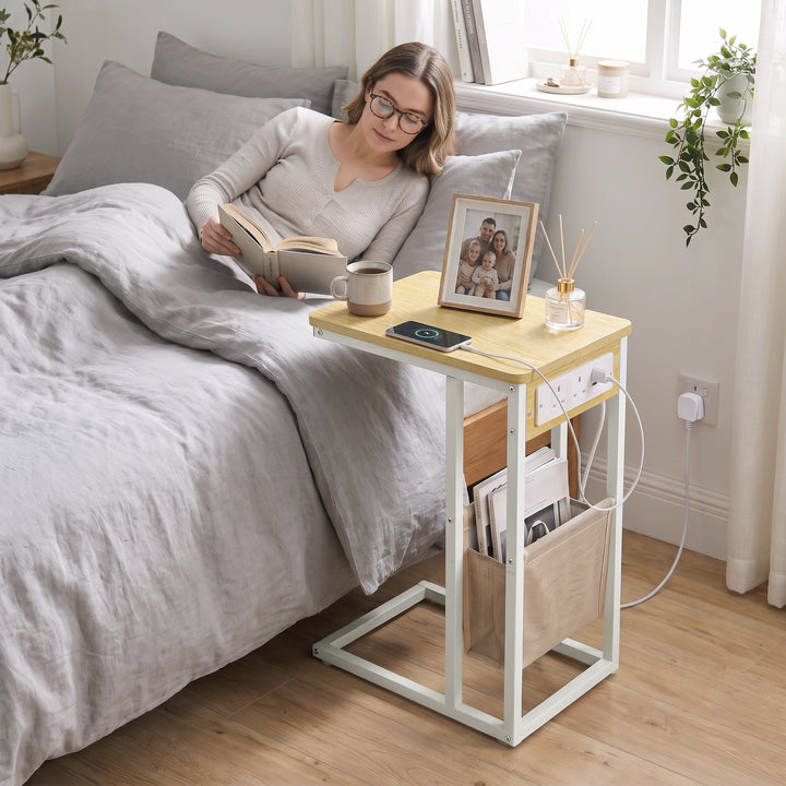 [Oak] side table beside bed with oak-effect top, charging station, lamp, phone and storage pouch