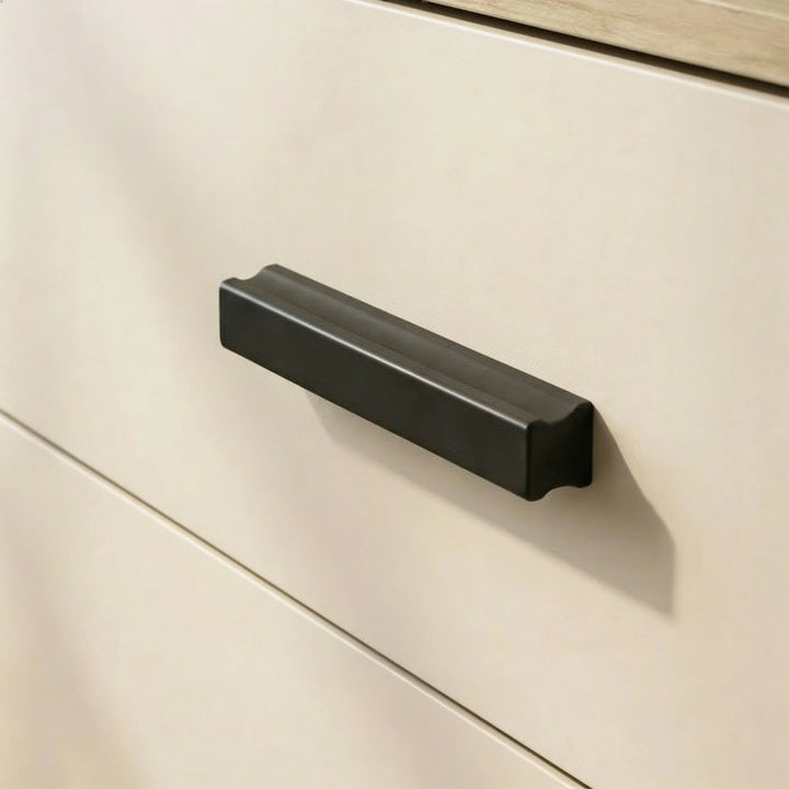 [Oak + Cashmere] Close view of black wooden handle mounted on cashmere drawer front framed by oak wood texture