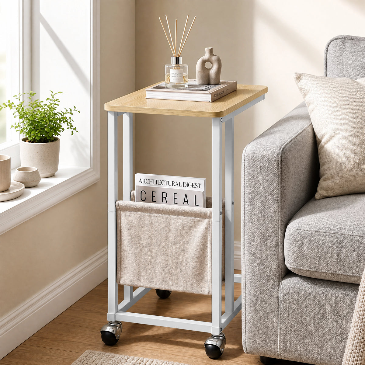 [Oak] compact side table beside sofa with oak-effect top, slim frame, pouch and caster wheels