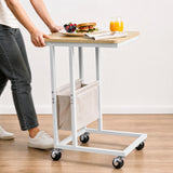 [Oak] movable side table being rolled on caster wheels with snacks and drink on tabletop