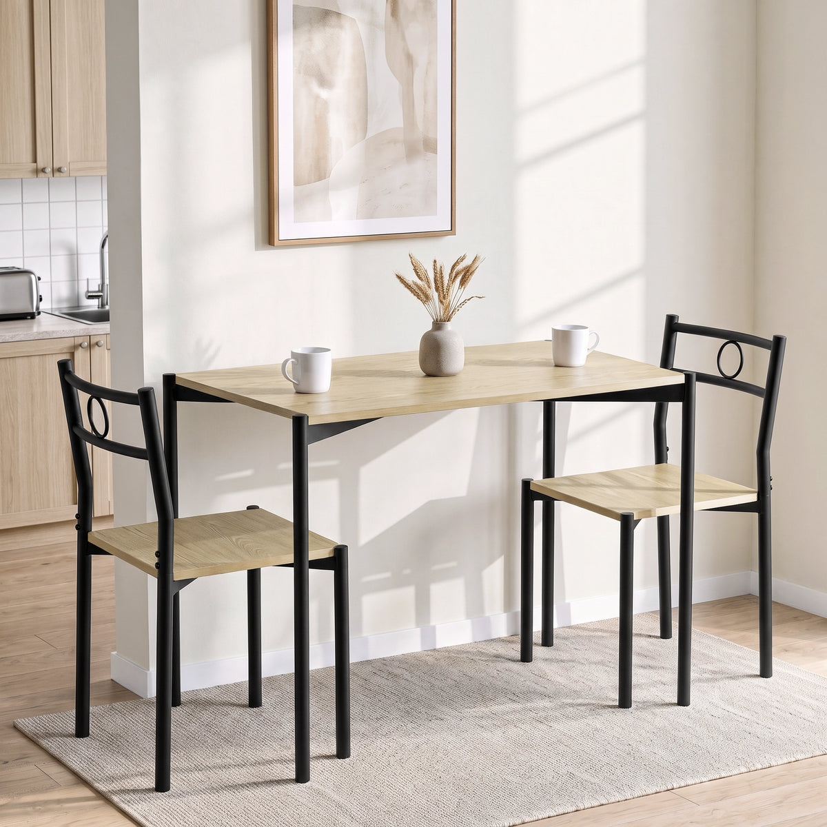 [Oak] Bright kitchen lifestyle view with the two-chair table set, two mugs, dried grass vase and framed wall art