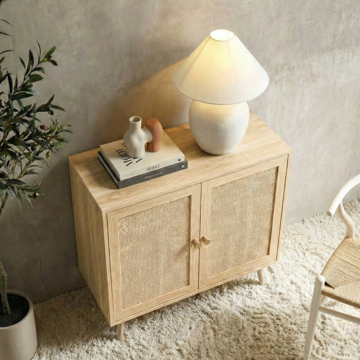 [Oak Effect] Wovena rattan sideboard from above on rug, olive tree left, lit lamp and books styled on top