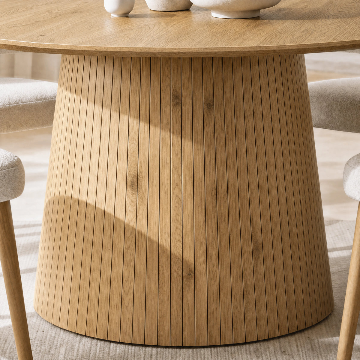 [Oak] Close-up of round pedestal dining table slatted pedestal base and wood-effect finish