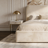 [King | Beige] Side angle of Pluva ottoman bed showing curved headboard profile and clean velvet base beside nightstand