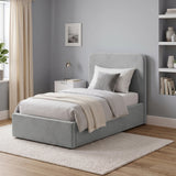 [Single | Light Grey] Angled bedroom view with rounded headboard, white bedding, shelf decor, curtain and rug