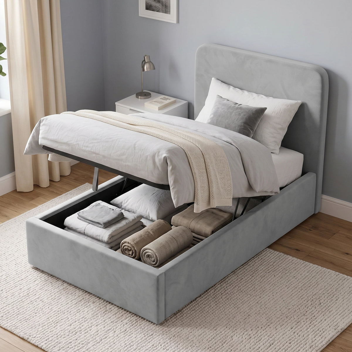 [Single | Light Grey] Ottoman base raised on gas struts showing stored pillows, folded bedding and rolled throws