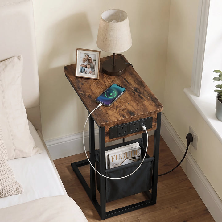[Rustic] Top view of C-shaped side table with rustic wood-effect top, charging cable, phone and pouch used as bed side table