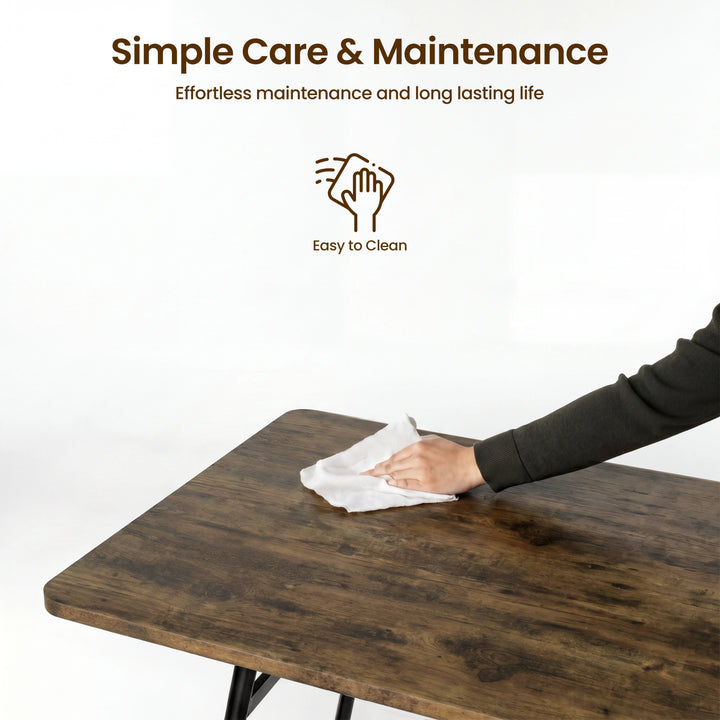 [Rustic] Torvi dining table easy-clean surface detail showing person wiping the dark rustic MDF tabletop with a cloth on a white background