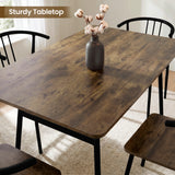 [Rustic] Torvi dining table overhead close-up showing dark rustic wood-effect tabletop surface with a cotton stem vase and black metal arm chairs around it