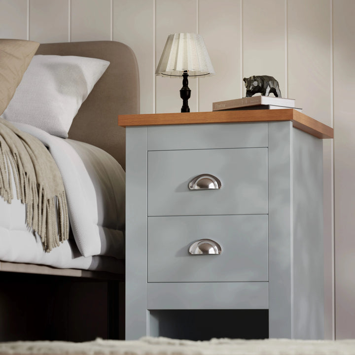 [Grey] grey nightstand with oak-effect top and two chrome cup handles, table lamp and small bear figurine on top