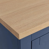 [Blue] Close-up of a wardrobe corner showing a oak wood veneer countertop with a blue cabinet base.