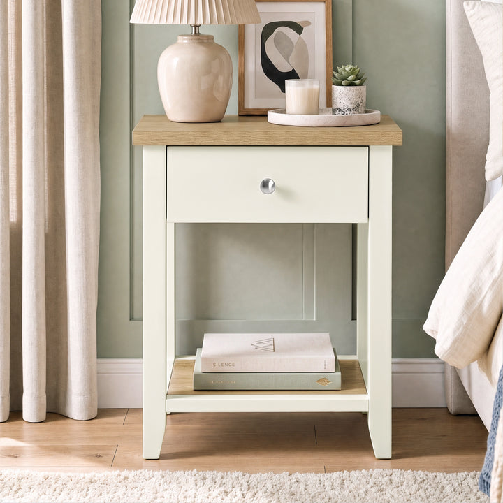 [White] Bedside lifestyle view with lamp on top, closed drawer and books on the lower shelf