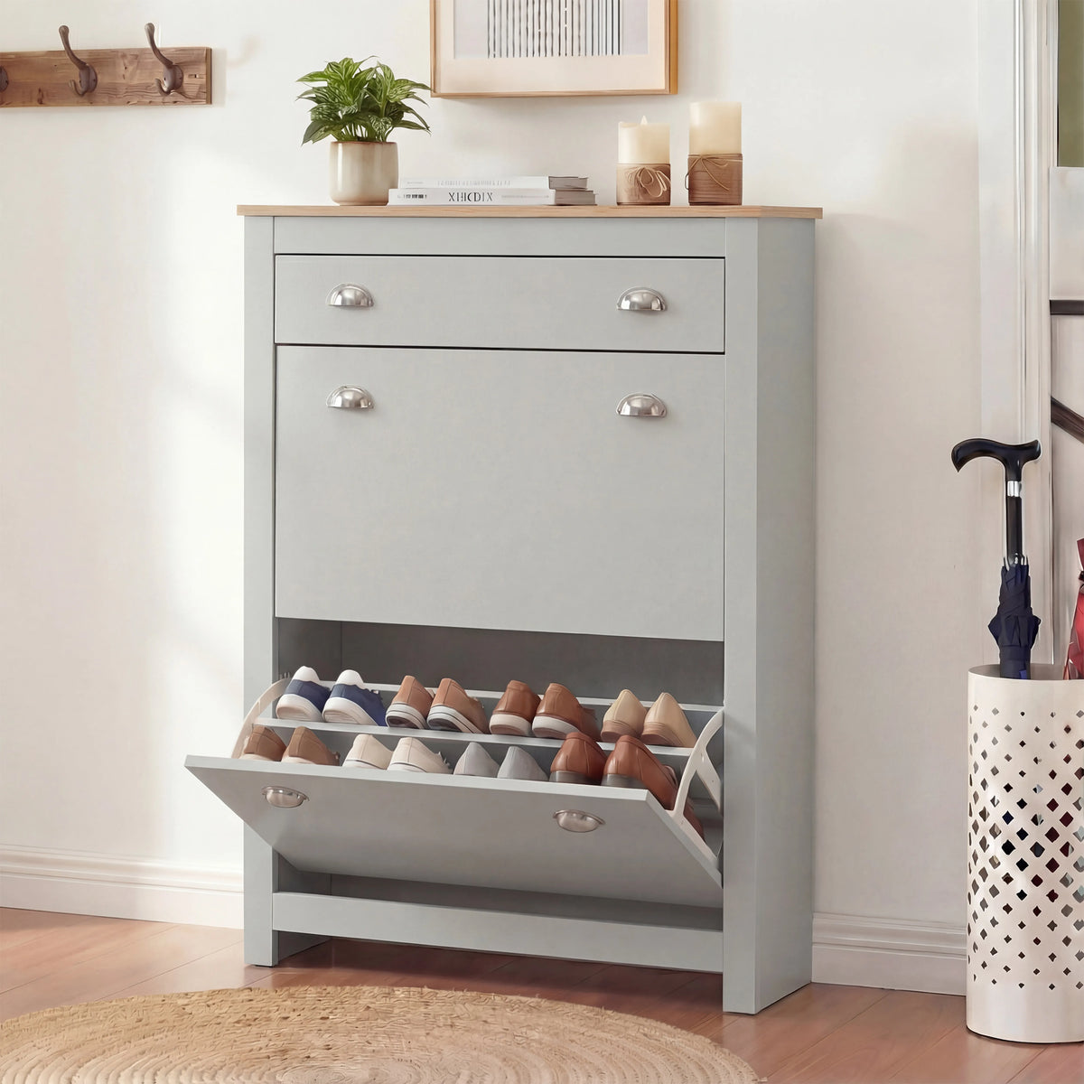 [Grey] Slim grey shoe cabinet front view, bottom compartment open beside white perforated umbrella stand