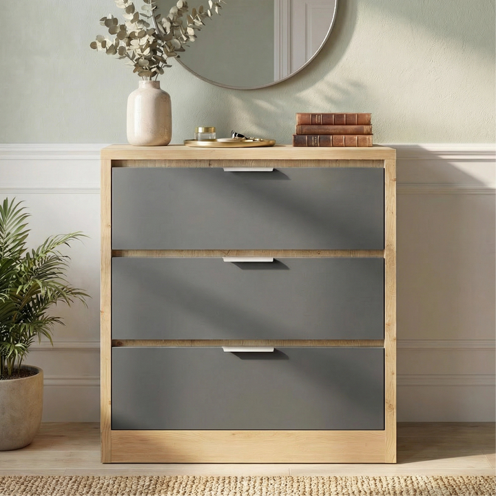 [Oak+Grey] Skova chest of drawers from the side, oak top with vase and round mirror behind on green wall