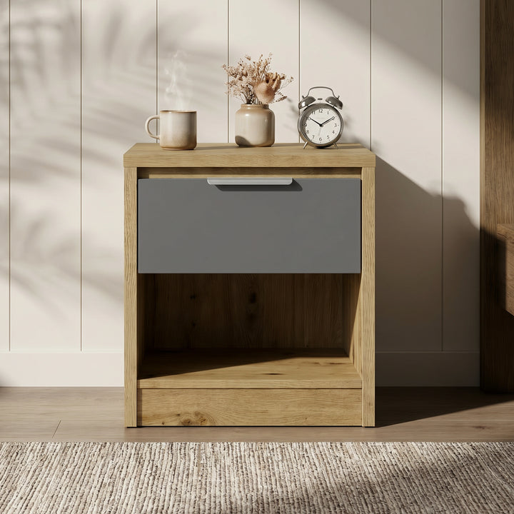 [Oak+Grey]  Wooden nightstand with a gray drawer and decorative items on top against a neutral wall.