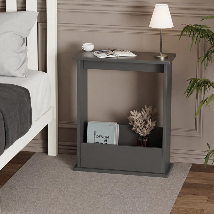 [Slate Grey] Narrow Side Table used as bedside nightstand with table lamp, open book, coffee cup, pampas grass, and magazines tucked below