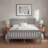 [Grey] wooden double bed frame angled grey footboard, white duvet, open book and lamp with beige shade