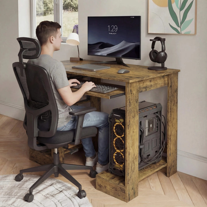 [Rustic] Rustic home office computer desk scene with mesh task chair pulled in, person typing at extended tray