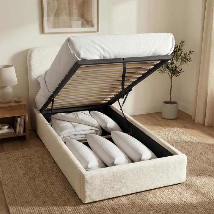 [White | Single] Boucle ottoman bed with gas lift raised from foot end, wooden slats and central iron support bar visible