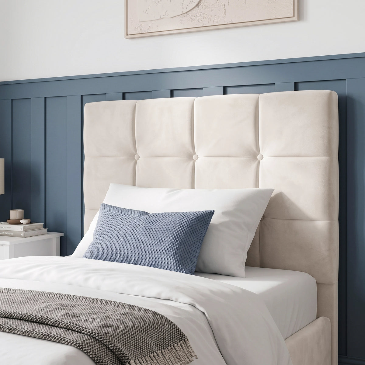 [Single | Beige] upholstered headboard in a warm belge velvet fabric, shown on a bed in a styled bedroom with blue paneled wall, white bedding, and a blue accent pillow.