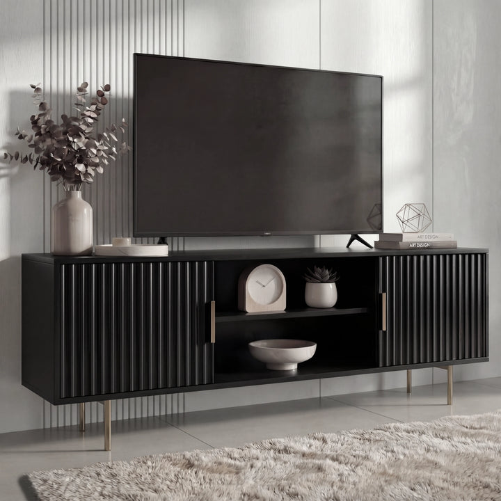[Black]  Lifestyle view of black Flutrina TV unit, ribbed cabinet doors and open mid shelf holding clock and bowl