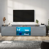 [Grey] TV stand unit in grey gloss with wall-mounted TV above and headphones plus console on lit shelf
