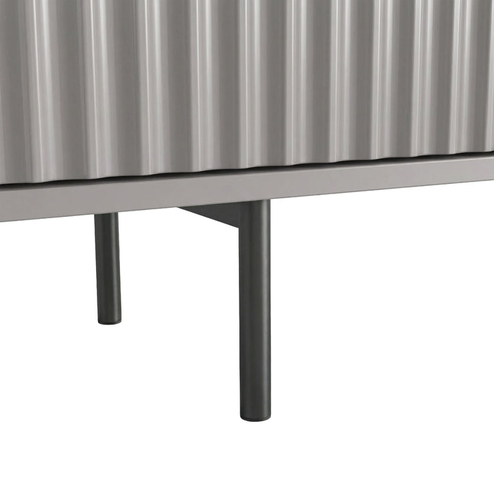 [Grey] Close-up of two slim dark legs at base of grey Flutrina 180cm TV unit on light tile floor.
