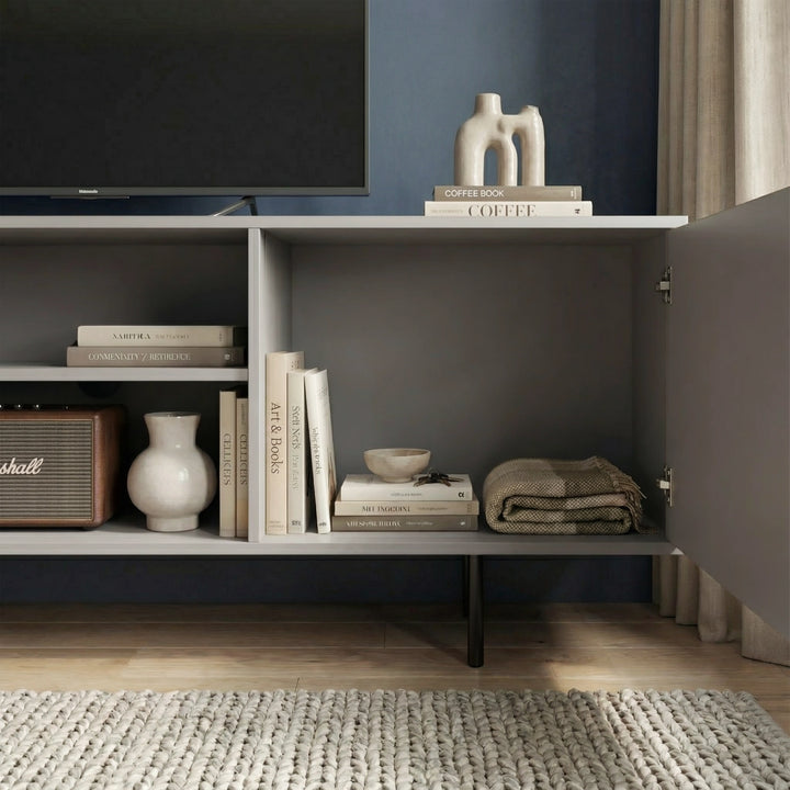 [Grey]  Close-up of grey Flutrina TV unit base showing fluted door bottom and a slim dark cylindrical metal leg