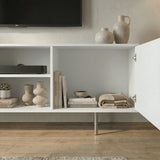 [White] Open-door view of white TV unit, ceramic jugs on top, internal compartments showing books and folded textiles.