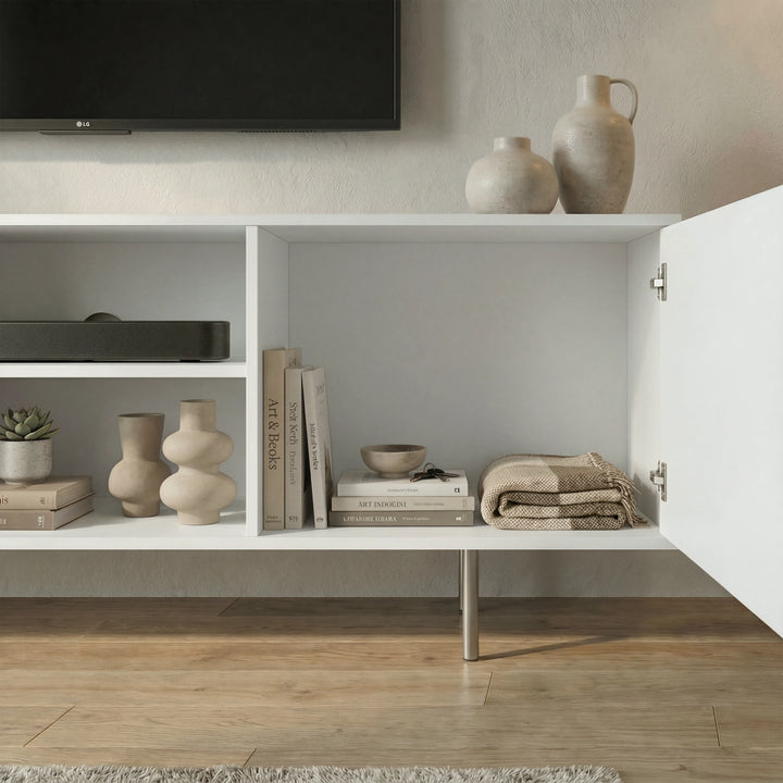 [White] Open-door view of white TV unit, ceramic jugs on top, internal compartments showing books and folded textiles.