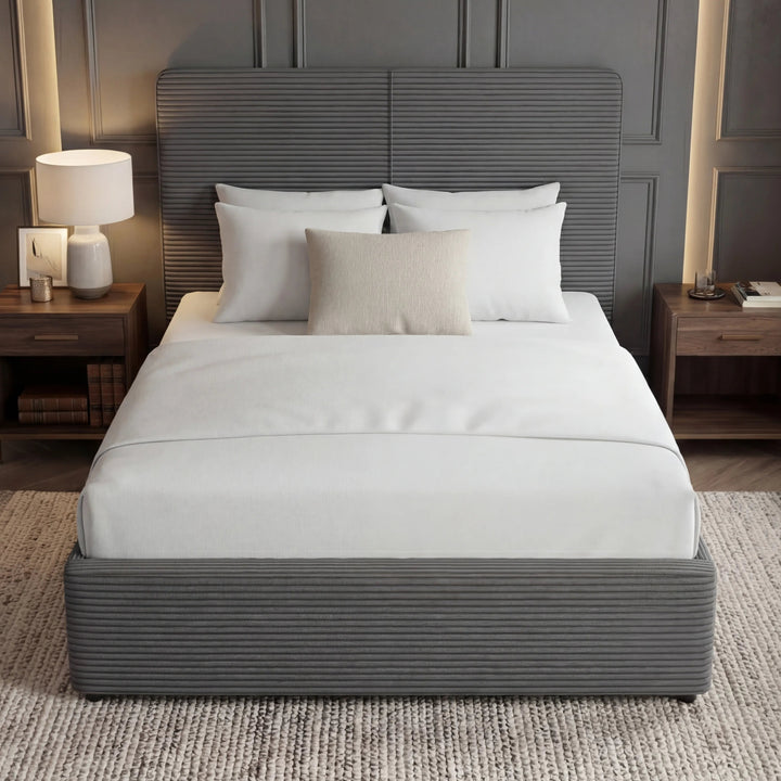 [Double | Grey] Double velvet ottoman bed set mid-room against dark panelling with wall lamps flanking the headboard