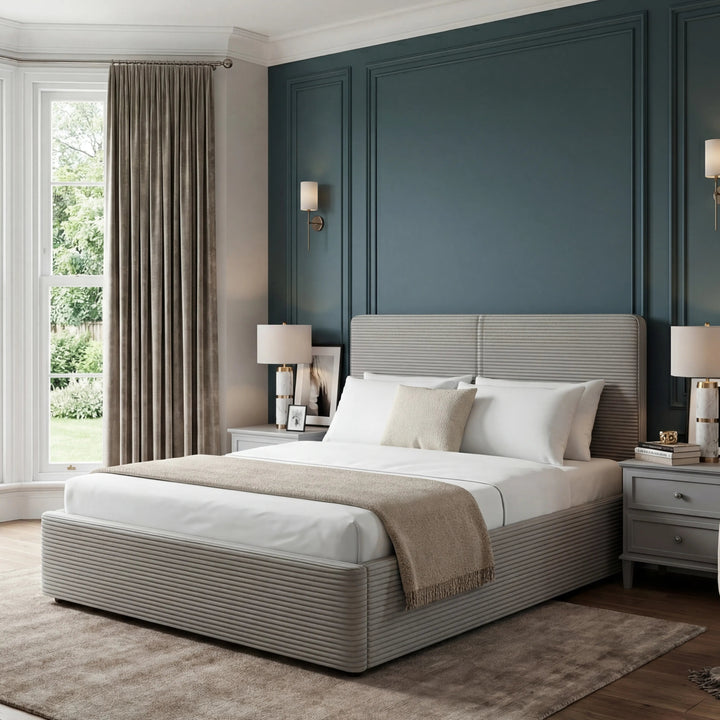 [Double | Light Grey] Velvet ottoman bed double in light grey staged in a bedroom with curtained window and nightstand