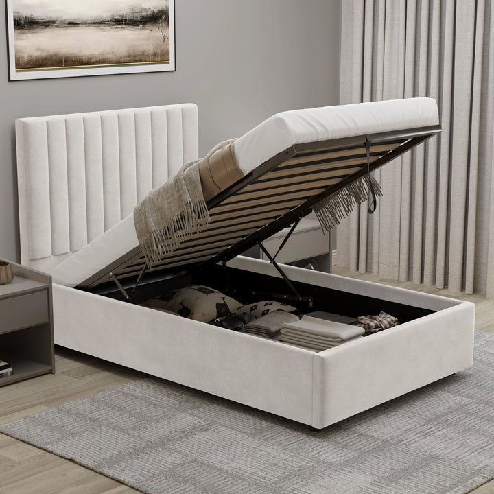 [Beige | Single] velvet ottoman bed with gas-lift raised showing organised storage with folded linens and pillows