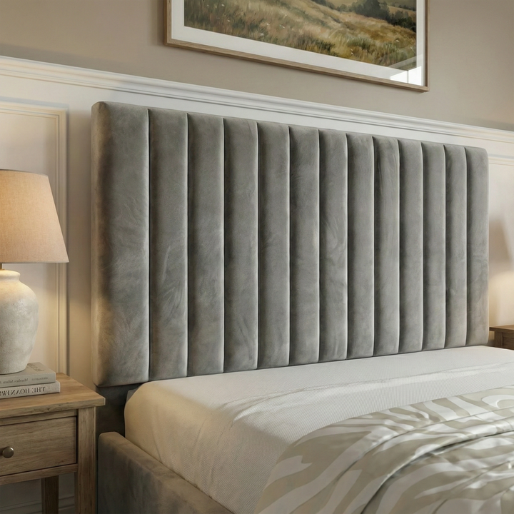 [Grey | Small Double] bed frame Headboard close-up displaying tall vertical pleats in velvet with warm glow from bedside lamp