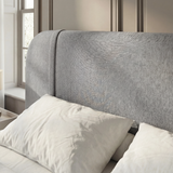 [Double | Grey] Headboard detail with gentle curved top edge and padded wingback shape against panelled wall